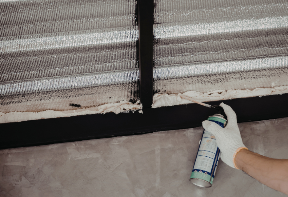 close up view of hand using can of sealant on the building envelop
